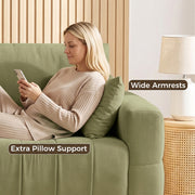 Woman relaxing against the wide armrest of the green sofa with an extra pillow