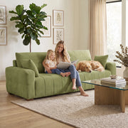 Mother and child reading on the green sofa next to a golden retriever