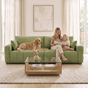 Family and dog on the green 3 seater sofa in front of a glass coffee table