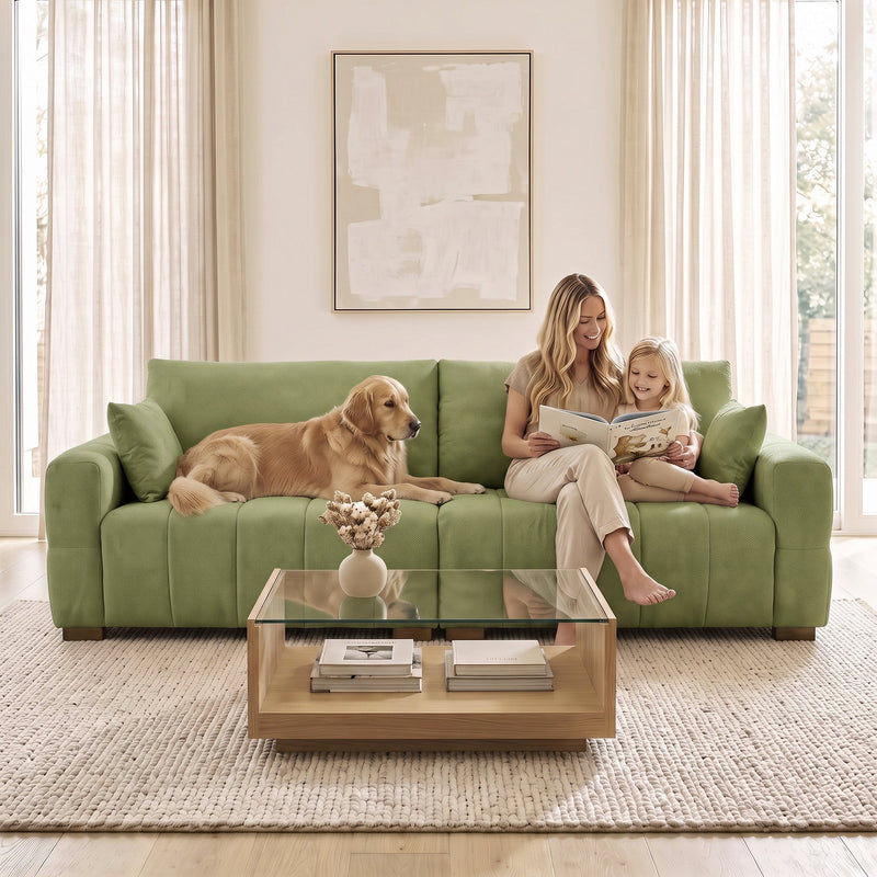 Family and dog on the green 3 seater sofa in front of a glass coffee table