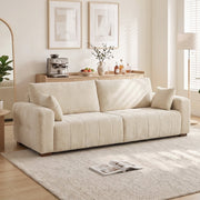 Cream white 3 seater sofa in a bright living room beside a floor lamp and rug