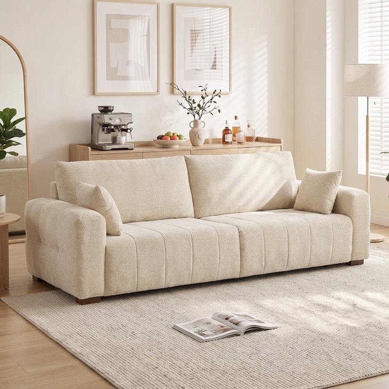 Cream white 3 seater sofa in a bright living room beside a floor lamp and rug