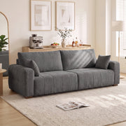 Grey 3 seater sofa in a bright living room beside a floor lamp and rug