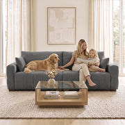 Family and dog on the grey 3 seater sofa in front of a glass coffee table