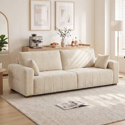 Cream white 3 seater sofa in a bright living room beside a floor lamp and rug