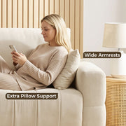 Woman relaxing against the wide armrest of the cream white sofa with an extra pillow