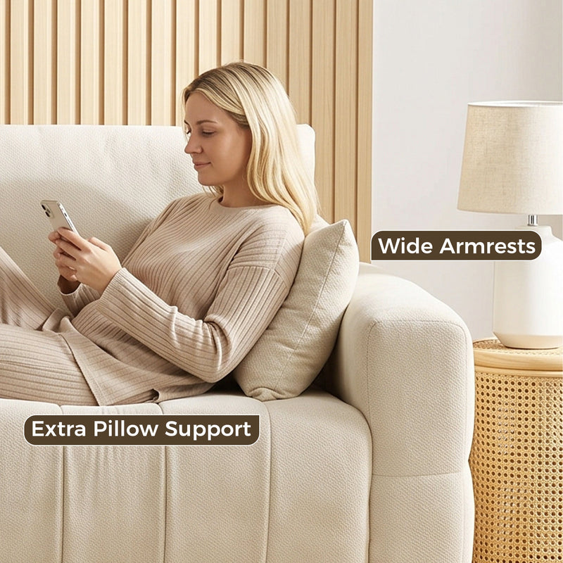 Woman relaxing against the wide armrest of the cream white sofa with an extra pillow