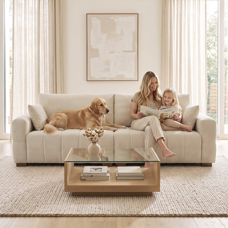 Family and dog on the cream white 3 seater sofa in front of a glass coffee table