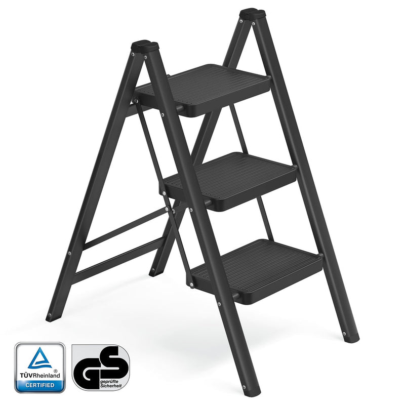Black 3-step folding ladder standing open, with TUV Rheinland and GS safety marks