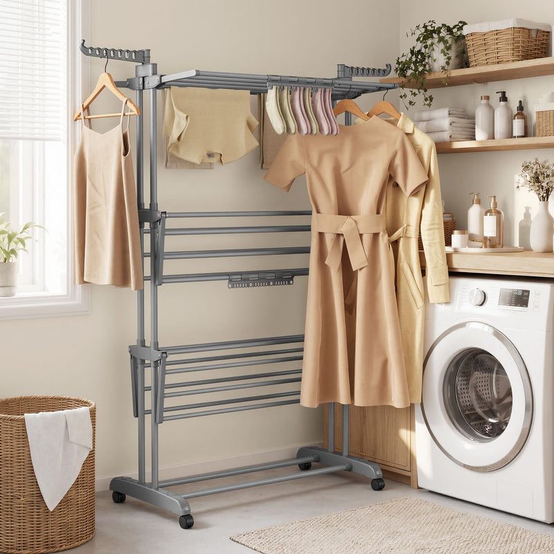 Grey clothes airer drying dresses beside a washing machine and laundry basket