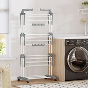 White 3-tier clothes airer standing empty next to a black washing machine