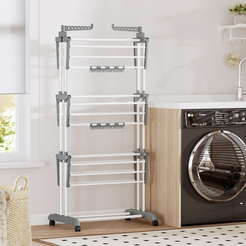 White 3-tier clothes airer standing empty next to a black washing machine