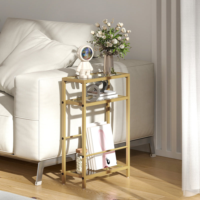 Gold glass side table beside a cream sofa styled with flowers, books and a figurine
