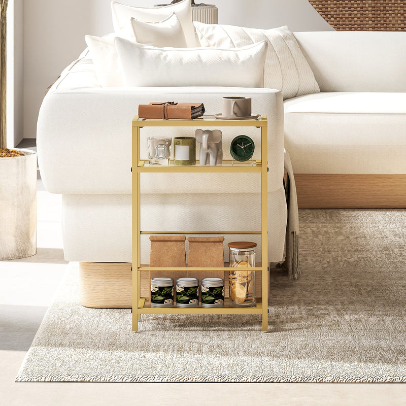 Gold side table beside a sofa styled with candles, jars and a small clock