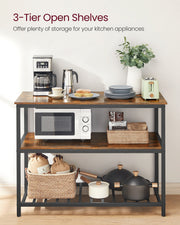 Three open shelves holding a microwave, baskets and pans in a bright kitchen
