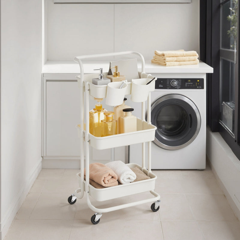 White storage trolley holding toiletries and towels beside a washing machine in a laundry room