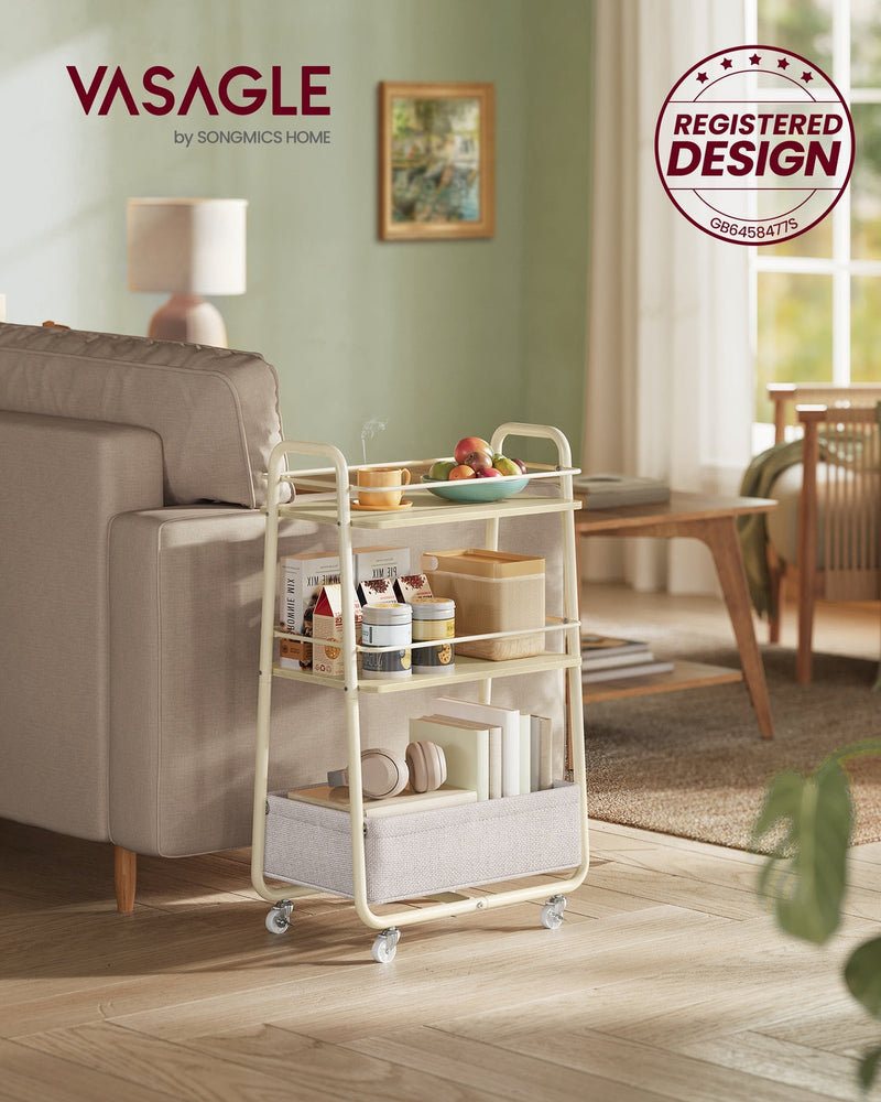 Vasagle beige storage trolley holding fruit and books beside a sofa in a living room