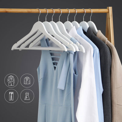 White wooden hangers on a wooden rail holding dresses, shirts and a coat