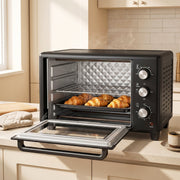 Black 30L mini oven with the door open and croissants on the rack