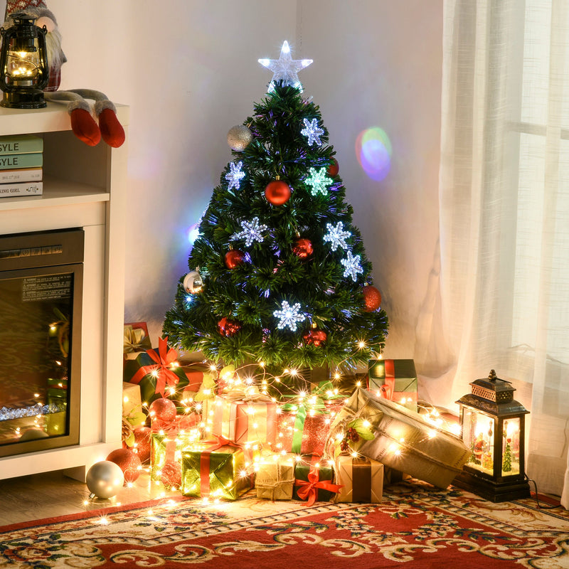 Lit tree in a room corner surrounded by wrapped gifts