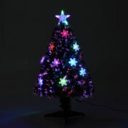 Tree glowing with multicolour lights against a dark background