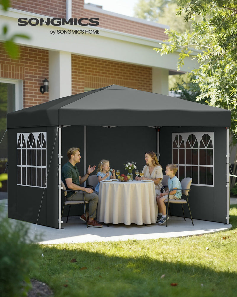 Family of four eating a meal at a round table under the dark grey gazebo in a garden
