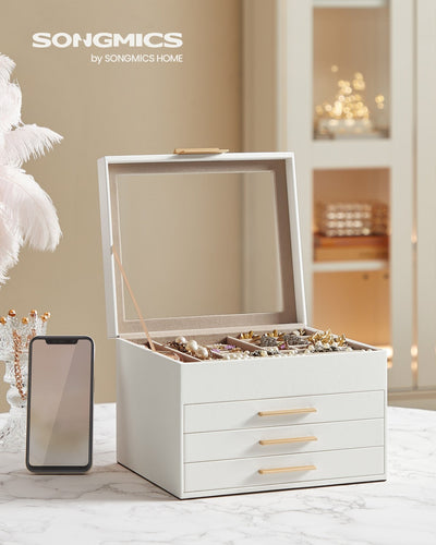 Open white jewellery box on a marble table beside a mobile phone showing its size