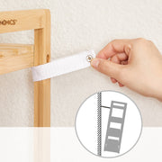 Hand fitting the anti-tip strap to the bamboo frame, with a wall fixing diagram