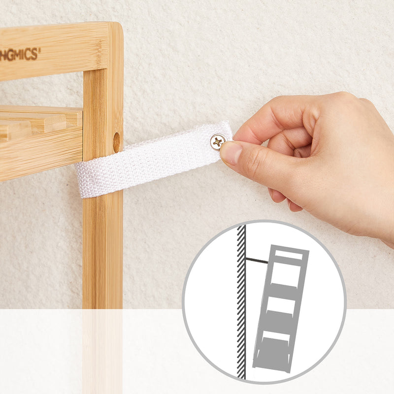 Hand fitting the anti-tip strap to the bamboo frame, with a wall fixing diagram
