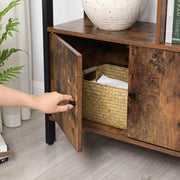 Close-up of a hand opening one cabinet door to reveal a woven basket inside