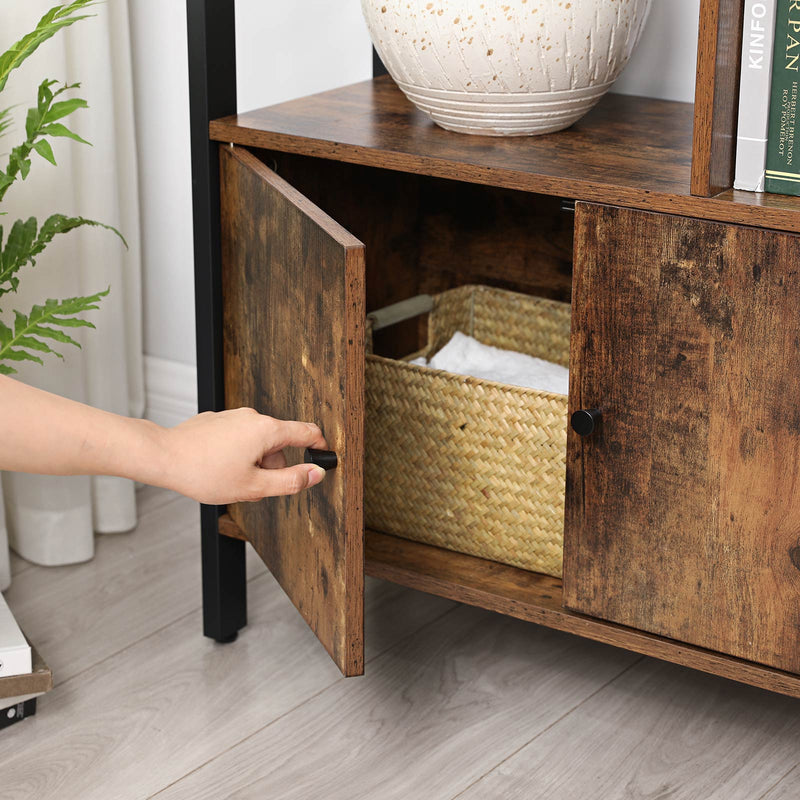 Close-up of a hand opening one cabinet door to reveal a woven basket inside