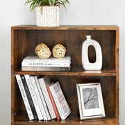 Close-up of two shelves holding books, a picture frame and woven ball ornaments