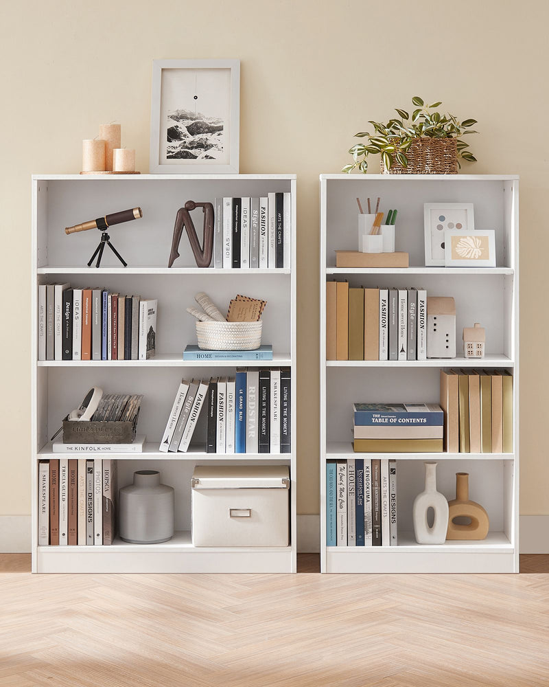 Two white 4-tier bookcases side by side against a wall filled with books