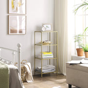 The gold glass shelving unit in a bedroom, stacked with books and folded linens