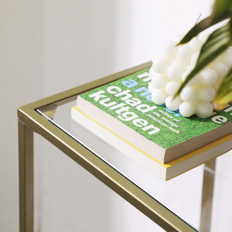Close-up of the gold steel frame corner and the polished glass shelf edge