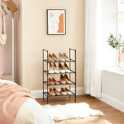 Black 4 tier shoe rack filled with shoes in a bedroom beside a window