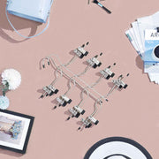 Flat lay of the pants hanger clips on a table surrounded by accessories
