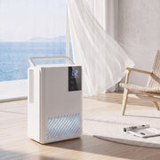 HOMCOM white dehumidifier lifestyle shot beside a floor-to-ceiling window with sea view
