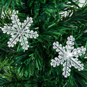 Close-up of clear LED snowflakes on green branches