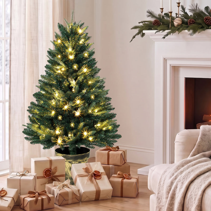 Pre-lit 4ft Christmas tree in a living room beside a fireplace with wrapped gifts around the pot