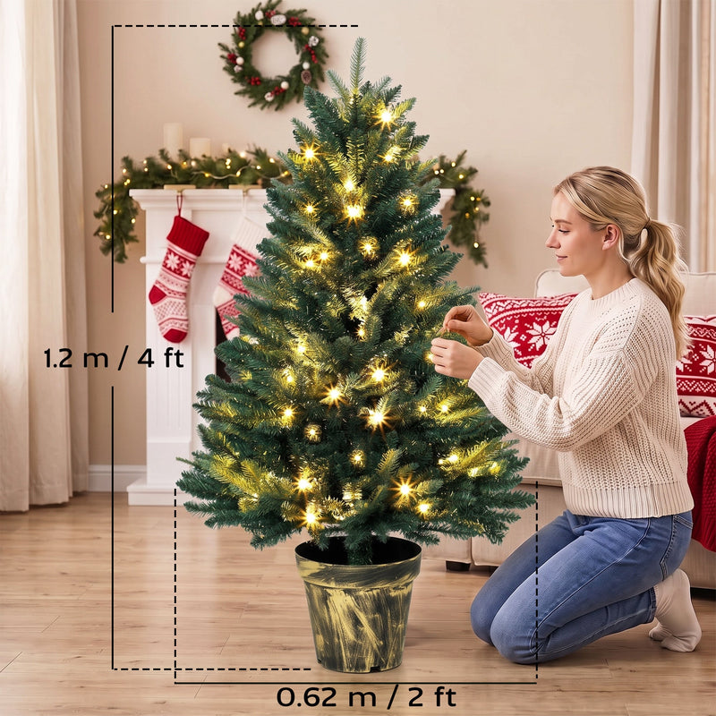 Woman decorating the tree with size labels showing 1.2 m (4ft) height and 0.62 m (2ft) width