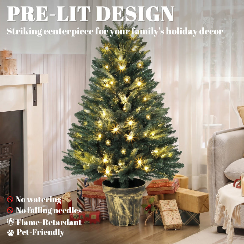 Pre-lit tree beside a fireplace with text listing no watering, no falling needles and flame-retardant
