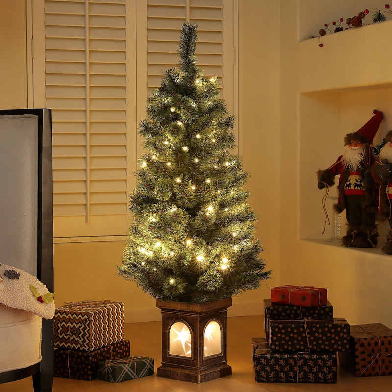 Lit 4ft Christmas tree with warm white LEDs in a living room with gifts