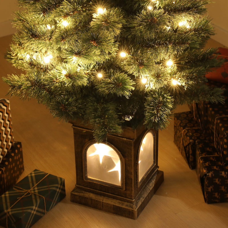 Close-up of the glowing square base and lower branches with warm white lights