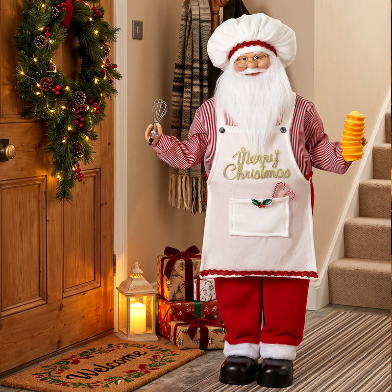 Chef Santa figure in a hallway beside a wreath and welcome mat