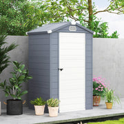 Grey plastic garden shed with the door shut, standing against a wall beside potted plants