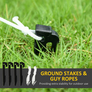 Black ground stake with white guy rope in grass above four stakes and two ropes