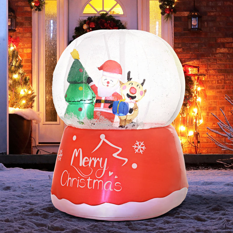Lit snow globe inflatable in front of a decorated brick porch at dusk