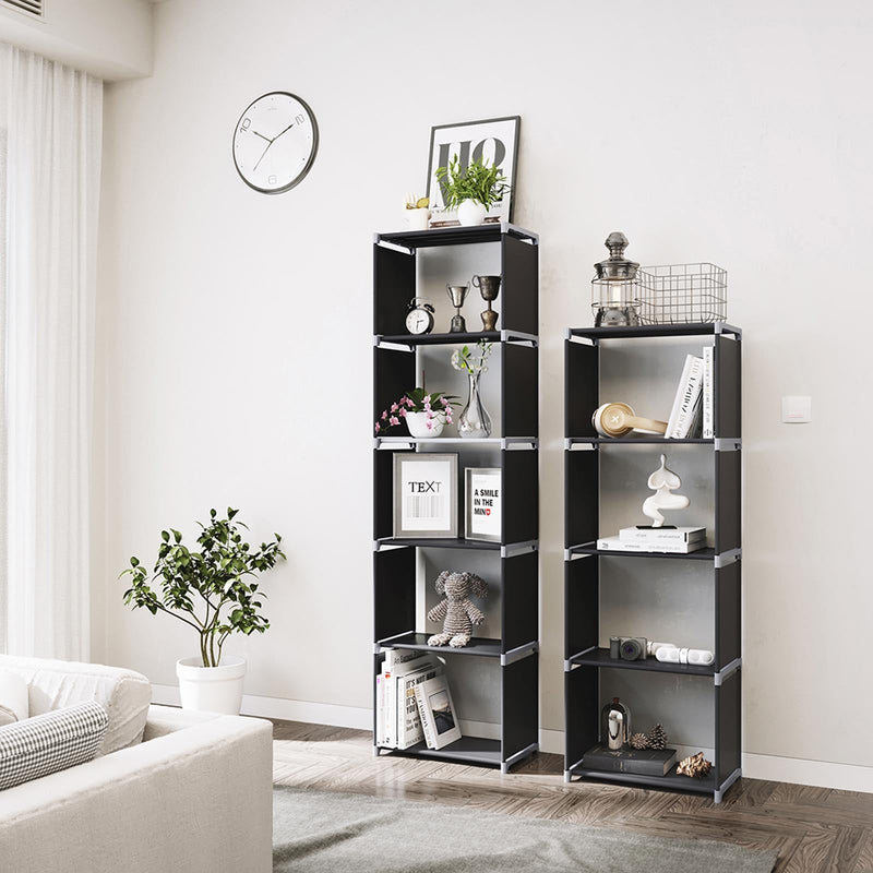 Two black cube units standing side by side in a living room holding books and ornaments