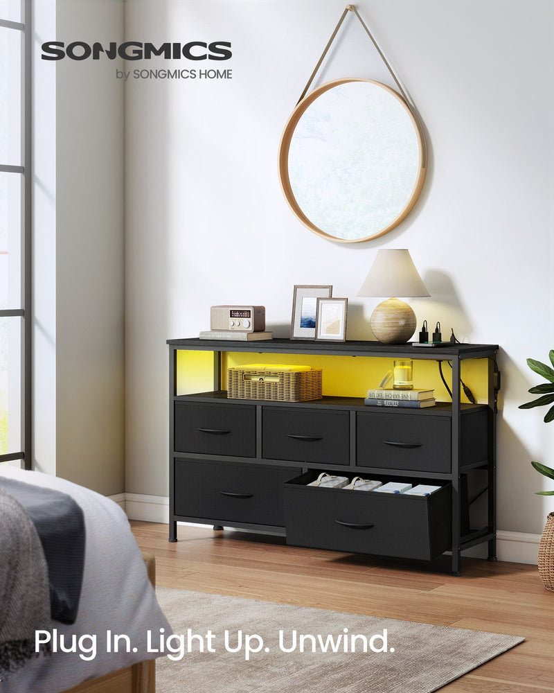 5 drawer chest of drawers in a bedroom with yellow LED lights, a round mirror above and one drawer open